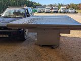 a table that is sitting on the ground in front of a truck
