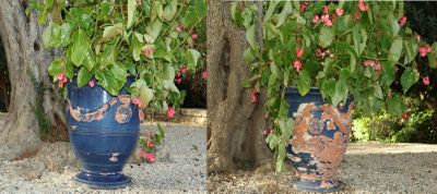 two vases with flowers in them sitting on the ground