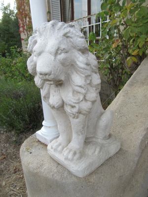 une statue représentant un lion assis sur un rebord