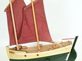 a model of a boat with red sails on a stand