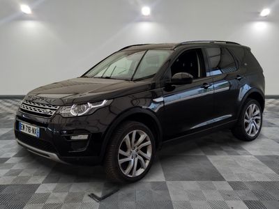 Une Land Rover noire est garée dans une pièce au sol carrelé en damier.