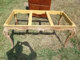 une table en bois avec un plateau en verre, posée dans l'herbe