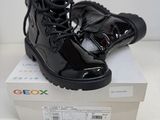 une paire de bottes noires posée sur une boîte