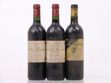 trois bouteilles de vin sont alignées sur une surface blanche