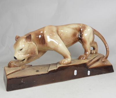 a figurine of a cat that is standing on a block