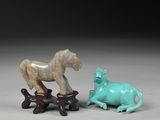 deux figurines représentant des chevaux et un chien posées sur une table