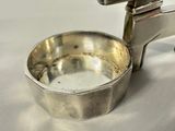 a silver cup with a handle on a white table
