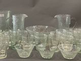 a lot of glasses and pitchers on the table