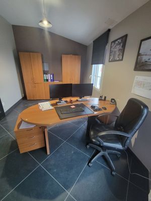 a desk with a computer and a chair in a room