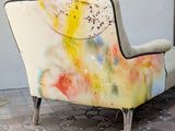 a colorful couch sitting on a tiled floor next to a wall