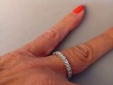 a woman ' s hand with a diamond ring on it