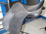 a saddle that is sitting on a stand in a room