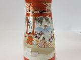 a vase with a painting on it sitting on a table