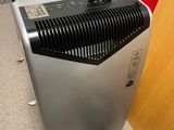 a small air purifier sitting on the floor next to a red wall
