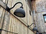 two lights on the side of a building that is made of wood