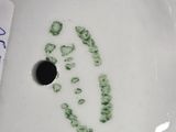 a white bowl with a green smiley face on it