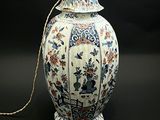 un vase blanc orné d'un motif bleu et rouge