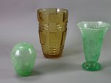 three different colored glass vases sitting next to each other