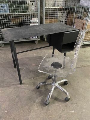 a desk with a chair and a computer on it in a warehouse