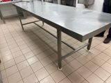 a large stainless steel table in the middle of a kitchen