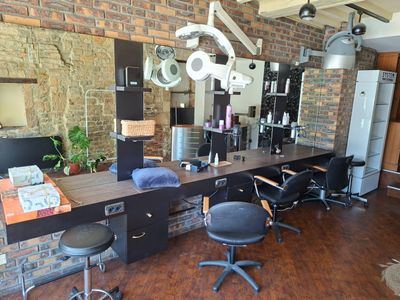 une photo d'un salon de coiffure avec un mur en briques
