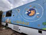 a blue bus with a picture of the earth painted on the side