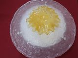 un gâteau blanc recouvert d'un glaçage jaune, posé sur une table rouge