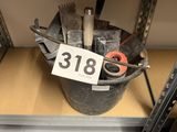un seau rempli d'outils posé sur une étagère, avec une étiquette de prix