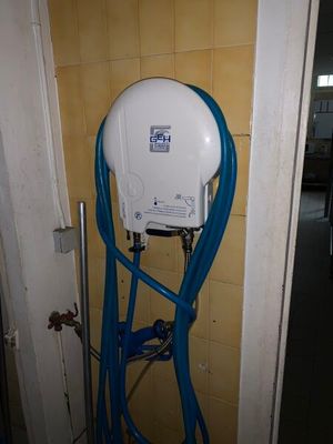 un tuyau bleu raccordé à des toilettes blanches dans une salle de bains