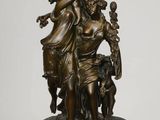 statue en bronze représentant une femme tenant un enfant et un chien, posée sur un socle en marbre