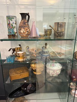 une vitrine en verre sur laquelle sont exposés de nombreux vases différents
