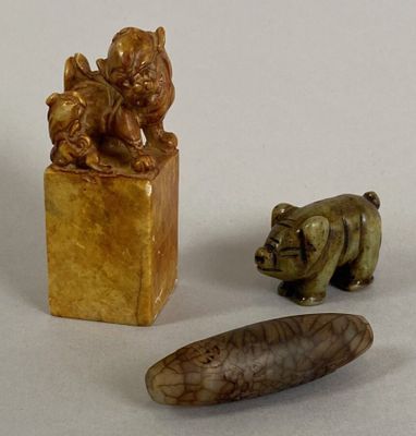 three small figurines of animals and a bear on display