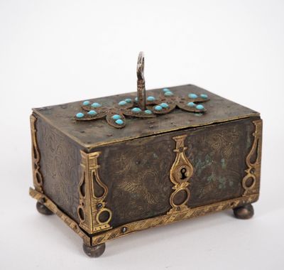 an antique brass box with turquoise stones on top of it