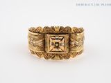 a close up of a gold ring with a square design on it