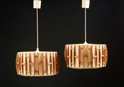 deux lampes en bois suspendues au plafond dans une pièce sombre