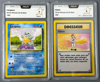 two pokemon cards are shown in plastic cases on a table