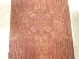 un vieux tapis orné d'un motif, posé sur le sol
