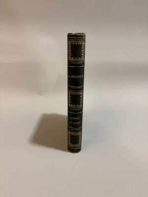 an old book sitting on top of a white table next to a white wall