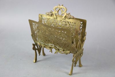 un porte-revues en métal doré posé sur une surface blanche