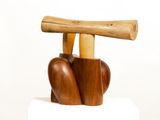 a wooden sculpture of a man sitting on top of a stool