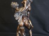bronze statue of a woman holding a child on her back
