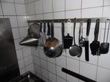 a picture of a kitchen with pots and pans hanging on the wall