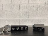 two electronic devices sitting on a table next to a brick wall