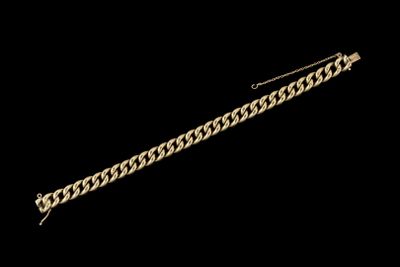 gros plan d'un bracelet en or sur fond noir