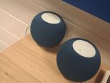 two speakers sitting on a wooden table next to a remote control