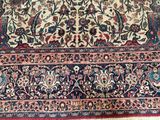 an antique persian rug with a floral design on a red ground