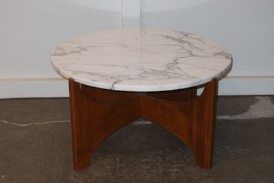 a marble top table with a wooden base in a room