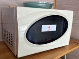 un micro-ondes posé sur une étagère en bois dans une pièce