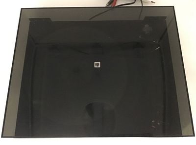 une photo d'une boîte en verre contenant un objet noir