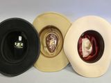 three hats are lined up in a row on a white surface